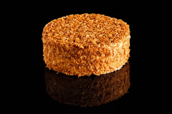 Caramel cake with cream filling coated with caramel flakes. Confectionery photography concept.