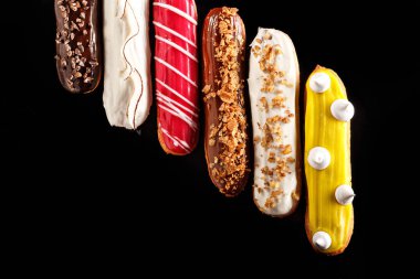 Siyah arkaplanda şekerleme fotoğrafçılığı konsepti için krema, fındık ve zarif dekoratif malzemeler içeren çeşitli ekler-.