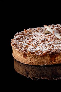 Üzerinde şeker tozu olan elmalı pasta ve sarılmış beyaz çikolata şekerlemesi. Fırın menüsü konsept odak portresi görünümü için fotoğraf.