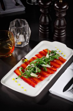 Üstünde yapraklar olan tütsülenmiş somon kaplaması. Asya menüsünde zarif bir kaplama. Dergi ya da restoran menüsü için yemek fotoğrafçılığı.