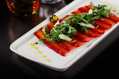 Üstünde yapraklar olan tütsülenmiş somon kaplaması. Asya menüsünde zarif bir kaplama. Dergi ya da restoran menüsü için yemek fotoğrafçılığı.