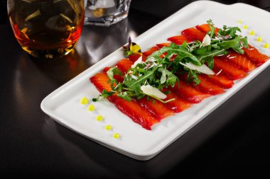 Üstünde yapraklar olan tütsülenmiş somon kaplaması. Asya menüsünde zarif bir kaplama. Dergi ya da restoran menüsü için yemek fotoğrafçılığı.