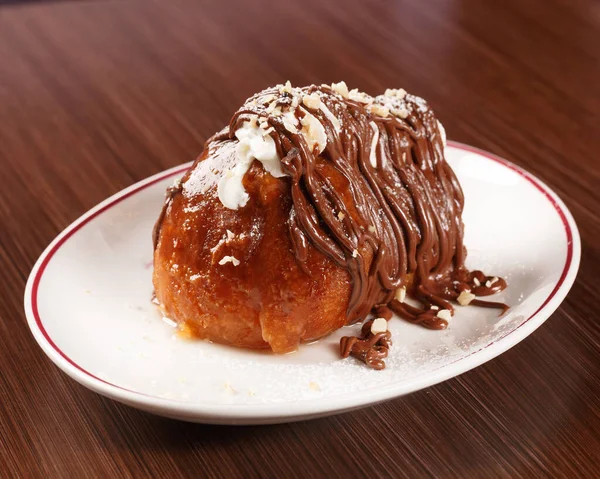 Traditional Italian desert with rum and Nutella cream. Wooden table.