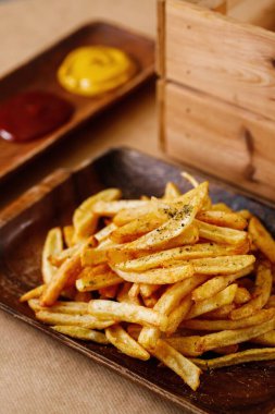 Ahşap tepside klasik patates kızartması tabağı harika aperatif tabağı. Dergi veya çevrimiçi dağıtım menüsü konsepti için Akdeniz mutfağı fotoğrafçılığı.