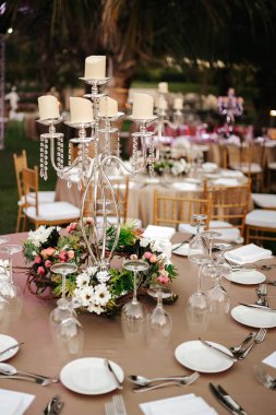 Uluslararası düğün açık havada, palmiye ağaçlarının altında bir kutlama partisi. Oteldeki yeşil alanda servis yaptım. Landyard. Bej ve pembe renkler. Yakın çekim ve geniş açı.