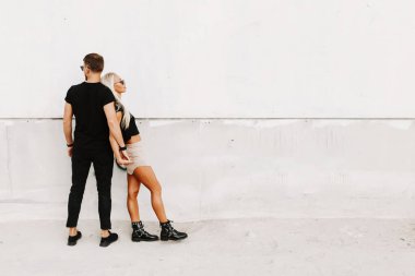 Hoş bir çift, samimi duygularla el ele tutuşarak vakit geçiriyor. Sokak moda fotoğrafçılığı beyaz arka planda reklam için kullanılabilir alan.