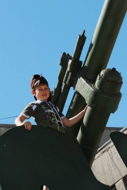 Çocuk ayakta duran bir tanka tırmandı.