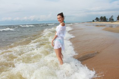 Kumsalda bir kız yürüyor.