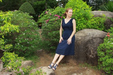 Girl sitting on a stone in a park