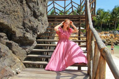 Tahta merdivenlerde oturan kız.