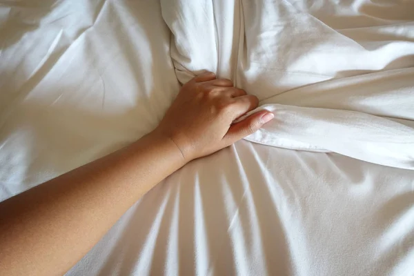 Mano de las mujeres tirando de sábanas blancas en éxtasis, orgasmo . — Foto de Stock