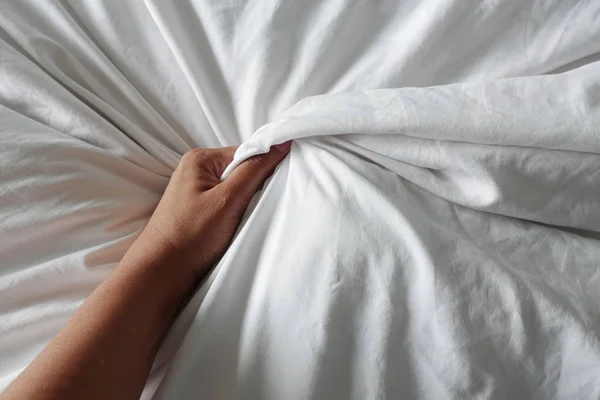 Mano de las mujeres tirando de sábanas blancas en éxtasis, orgasmo . — Foto de Stock