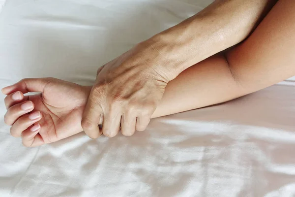Une main d'homme poilu tenant une main de femme pour viol et abus sexuels Image En Vente