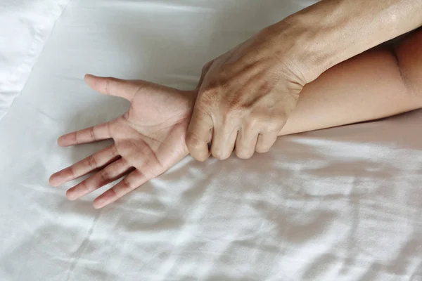 A mão de um homem peludo segurando uma mão mulher para estupro e abus sexual — Fotografia de Stock