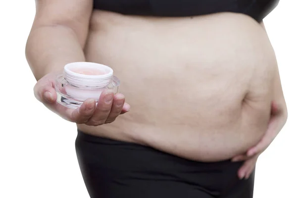 Hamile kadın WHI karşı izole karnı üzerinde krem uygulamak — Stok fotoğraf