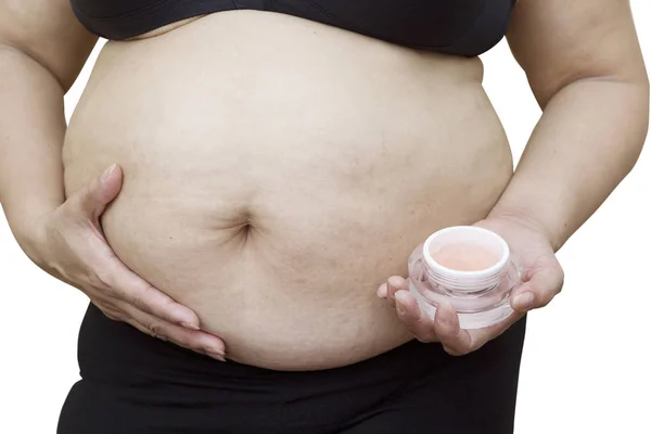 Gravid kvinna applicera kräm på hennes mage, isolerade mot whi — Stockfoto
