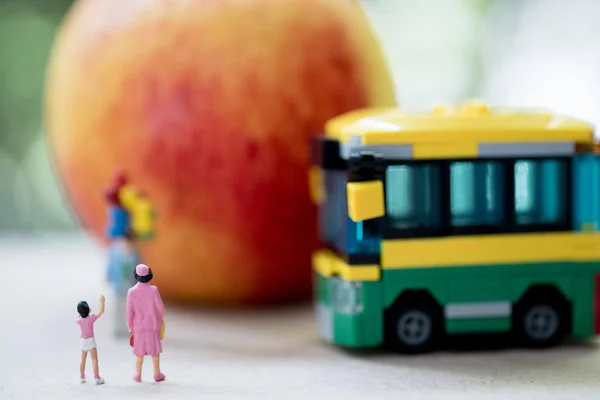 Miniature people: Childrens go to school with mother by school bus. Concept of back to school — Stock Photo, Image
