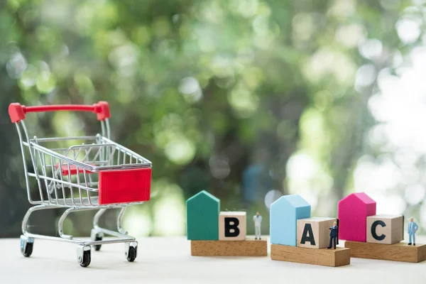Mini shopping cart and miniature people with home