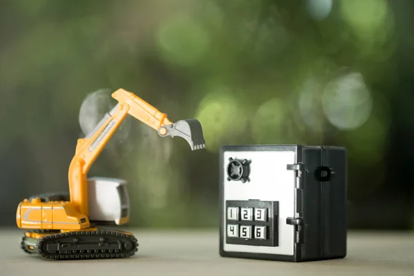 Miniature safe deposit with a code lock and excavator model toy.