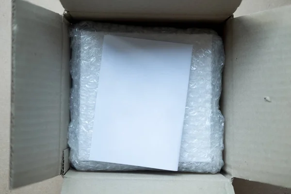 Paquete en caja marrón con envoltura de burbuja para producto de paquete de protección agrietado o seguro durante el tránsito en caja marrón — Foto de Stock