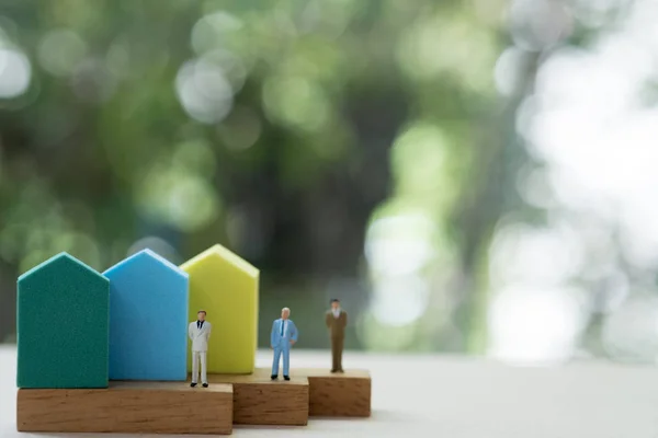Miniatura pessoas agente vender casa de pé com mini casa — Fotografia de Stock