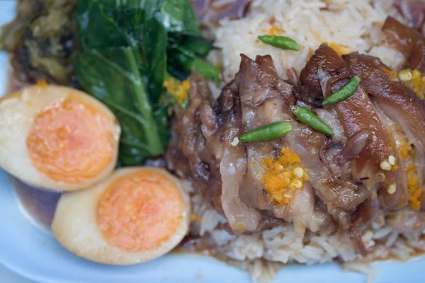 Gryderet svinekød ben på ris med kogt æg - Stock-foto