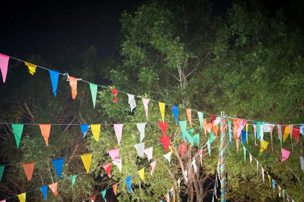 Viele bunte Dreiecksfahnen hängen in der Nacht an einem Draht — Stockfoto