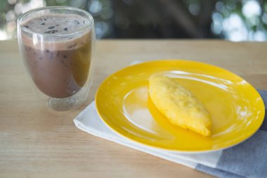 Kahvaltıda buzlu içecekle birlikte sarı tabakta servis edilen rulo omlet. Geleneksel yemek..