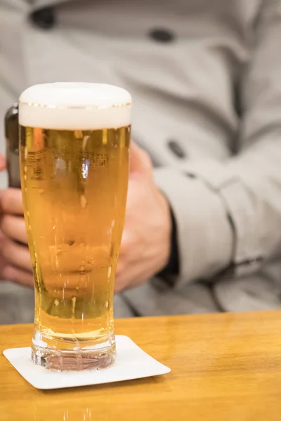 Vidrio refrigerado de cerveza ligera con hombres en suéter de fondo —  Fotos de Stock