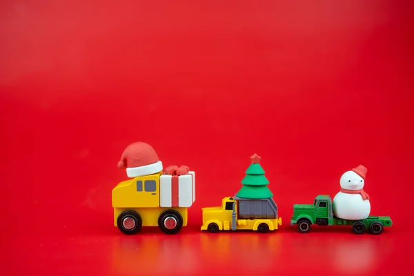 Speelgoedauto dragen kerstversiering. Levering van kerstgeschenken per vervoer en koeriersdienst. Creatieve kerstversiering — Stockfoto