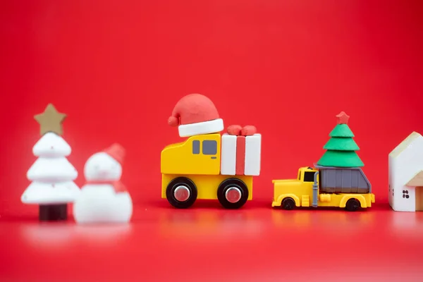 Speelgoedauto dragen kerstversiering. Levering van kerstgeschenken per vervoer en koeriersdienst. Creatieve kerstversiering — Stockfoto