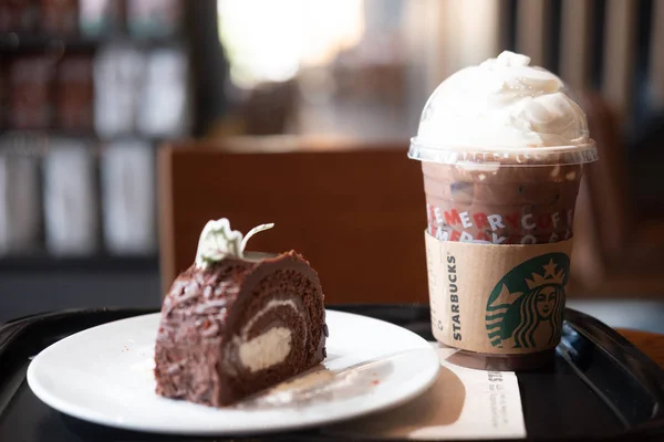 방콕, 태국 - 2019 년 12 월 13 일: 크리스마스 시즌에 스타 벅스 커피숍에서 파는 크림 과 크리스마스 로그 케이크를 곁들인 아이 스모카. 유명 한 커피 브랜드 프랜차이즈는 미국에서 시작되었다 — 스톡 사진