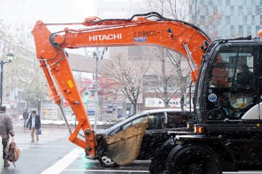 Sapporo, Japonya - 16 Kasım 2019: Sapporo şehir merkezindeki otomobil kazıcısı kış mevsiminde yol karla kaplıydı