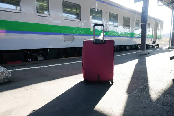 Travel by train. A suitcase stands near the train — Stock Photo, Image