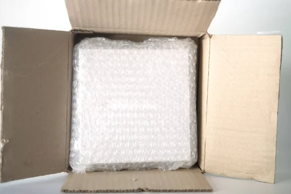 Kahverengi karton kutuda kullanılan kabarcık ambalajı plastik. — Stok fotoğraf