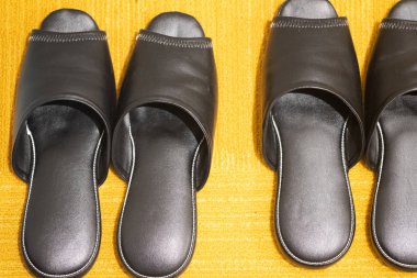 Yatak odasında yerde terlik var.