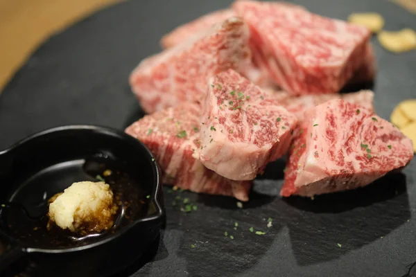 Grad premium de carne de vită japoneză feliată pe placa de piatră neagră — Fotografie, imagine de stoc