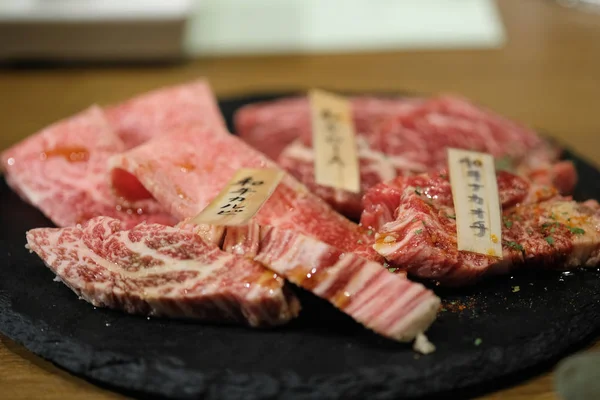 Grado Premium di carne giapponese affettata su piatto di pietra nera — Foto Stock