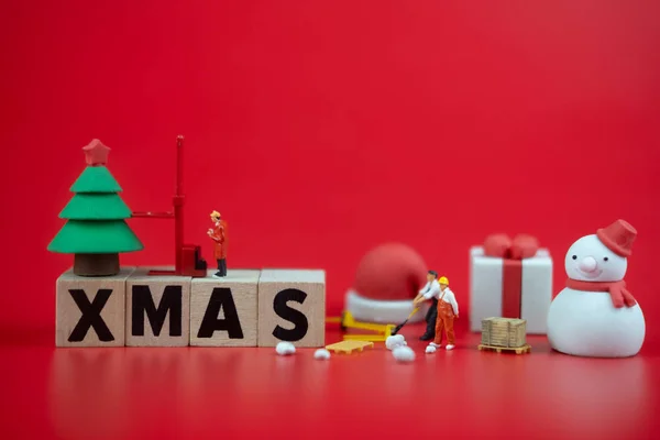 Miniatuur mensen: werknemer team voor te bereiden ornament voor decoratie in het kerstseizoen op rode achtergrond — Stockfoto