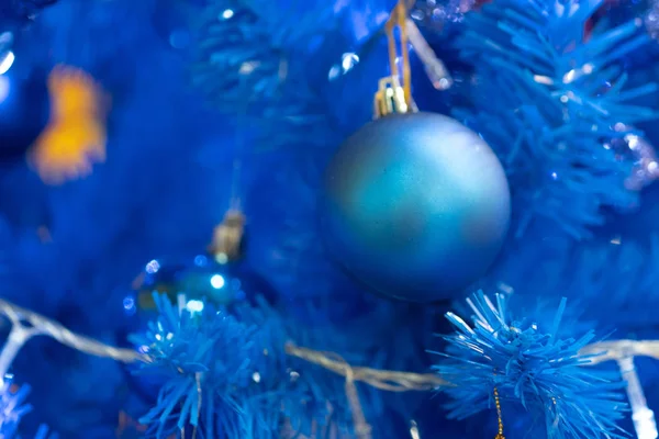 Blaue Kugel hängt an blauem Weihnachtsbaumzweig. — Stockfoto