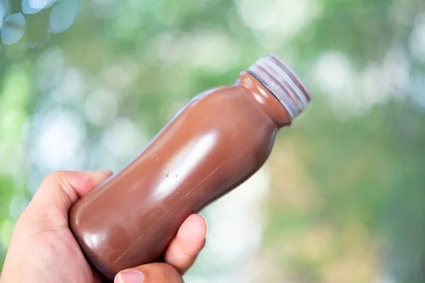 Холодный шоколад в пластиковой бутылке в руке — стоковое фото