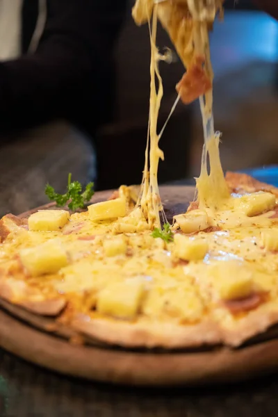 Scheibe heiße Pizza mit Käse in der Hand — Stockfoto