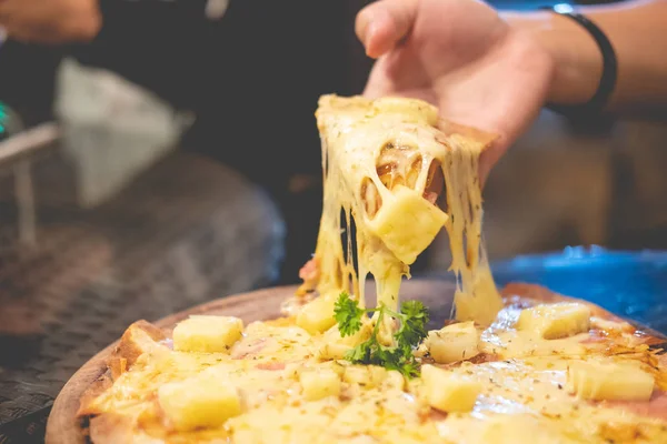 Scheibe heiße Pizza mit Käse in der Hand — Stockfoto