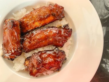 Pirinçte servis edilen barbekü soslu domuz kaburgası.