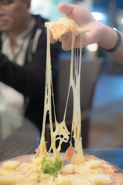 Fatia de pizza quente com queijo encorpado na mão — Fotografia de Stock