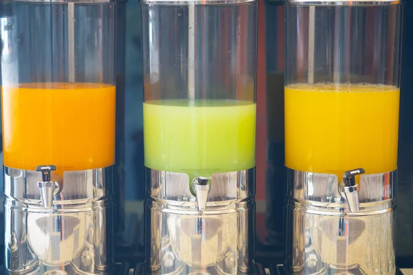Variety of juice in beverage dispenser for breakfast.