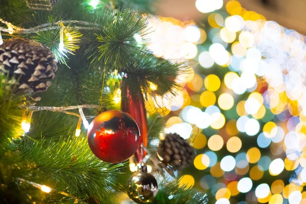 Sluiten Kerstballen opknoping op de tak van de dennen met nachtverlichting achtergrond. Kerstversiering om de feestdagen te vieren — Stockfoto