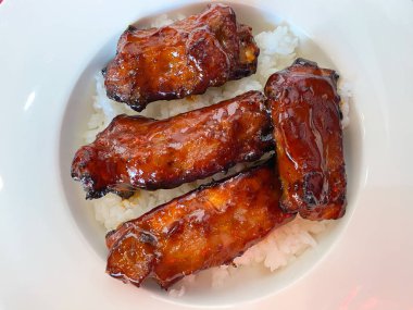 Pirinçte servis edilen barbekü soslu domuz kaburgası.