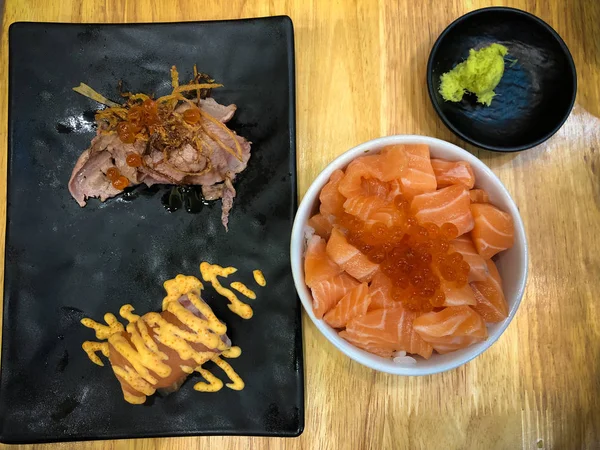 Tigela de arroz coberto com salmão e ovas de salmão servido com sushi — Fotografia de Stock