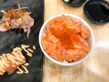 Somon balıklı pilav kasesi ve suşiyle servis edilen somon yumurtası. 